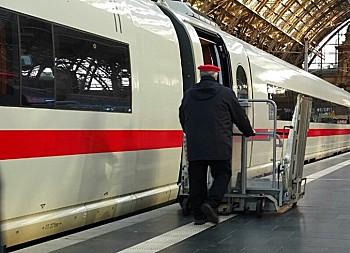 Ein Mitarbeiter der Deutschen Bahn bedient einen Hublift an einer geöffneten ICE-Tür
