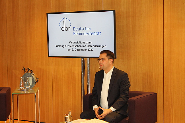 Das Foto zeigt Moderator Samuel Beuttler-Bohn, der auf einem Sofa sitzt