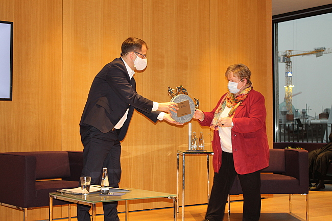 Samuel Beuttler-Bohn übergibt die Skulptur an Hannelore Loskill.