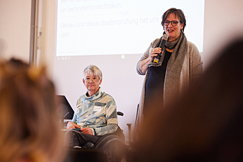 Begrüßung - durch die Sprecherinnenratsvorsitzende Prof. Dr. Sigrid Arnade (im Rollstuhl sitzend), Weibernetz, sowie die Koordinatorin des DBR-Sekretariats Martina Puschke (stehend), Weibernetz