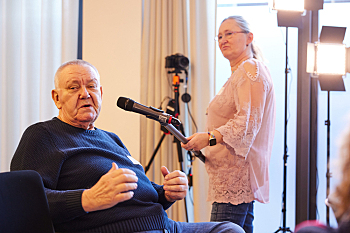 Blick ins Publikum - Redebeitrag von Joachim Szymmanowicz, KV der Gehörlosen Potsdam und Umgebung. Das Stabmikrofon wird von Antje Müller, Weibernetz, gehalten.