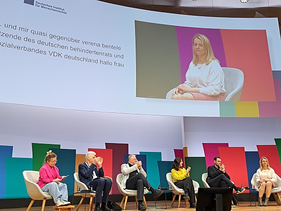 Blick auf das Podium mit den teilnehmenden Gästen bei der Veranstaltung zur UN-BRK. Ganz rechts sitzt DBR-Sprecherratsvorsitzende Verena Bentele.