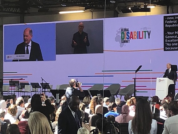 Die Bühne beim Global Disability Summit. Auf der Leinwand ist der damalige Bundeskanzler zu sehen.